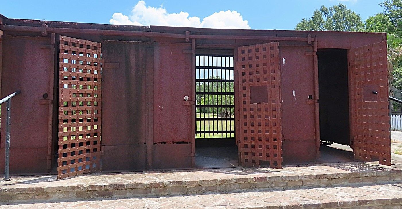 A rusty building with the doors open and stairs leading up to it.