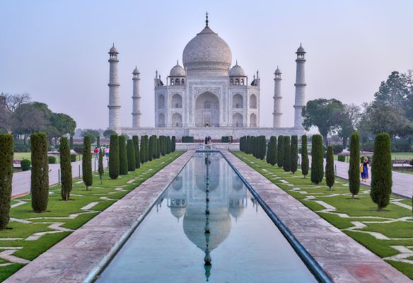 A view of the taj mahal with a pond in front of it