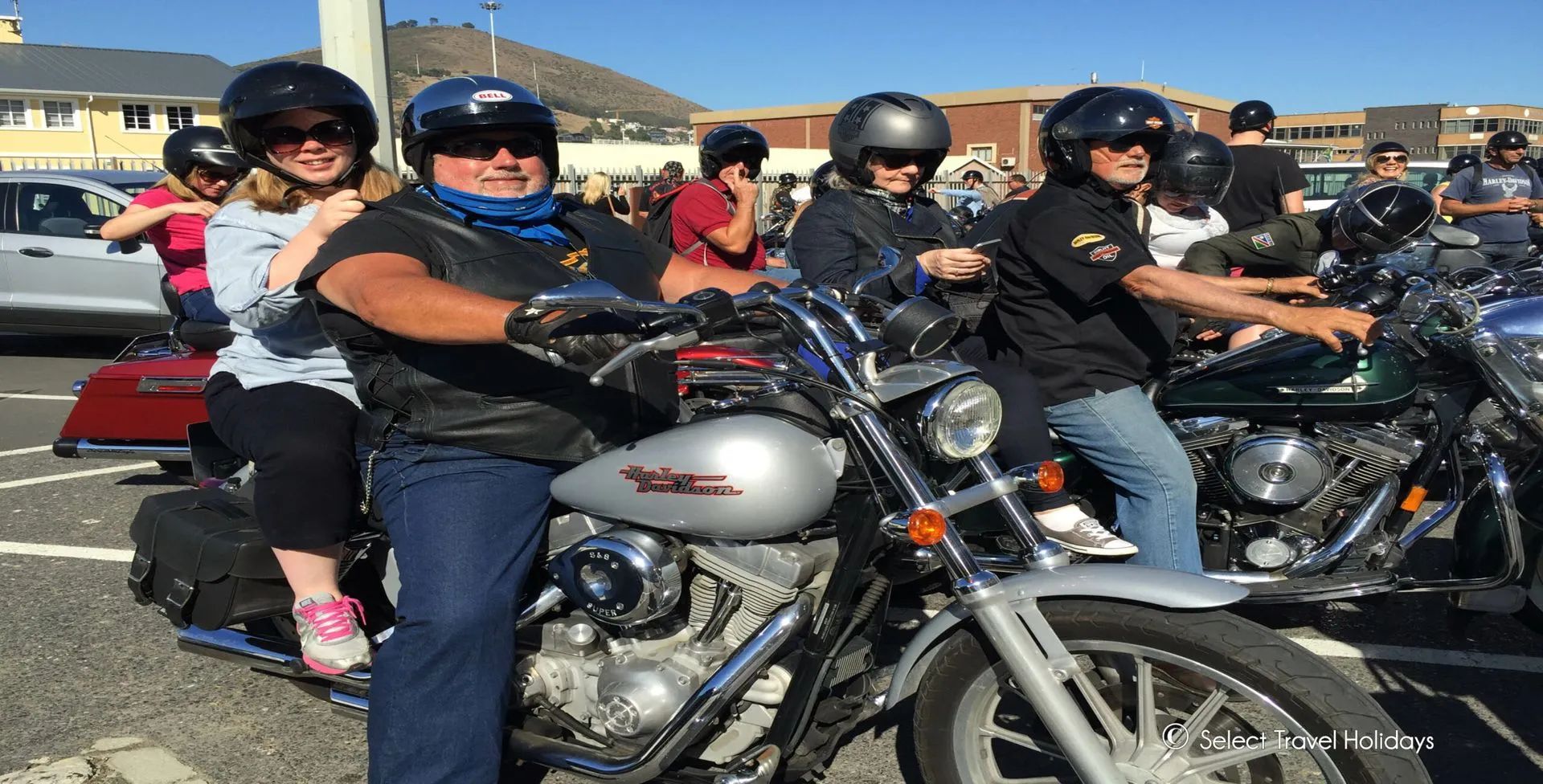 Group of people on motorcycles outdoors, with helmets, sunny day.