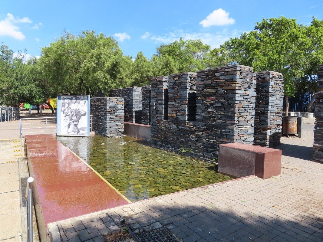 A stone wall with a pond in the middle of it