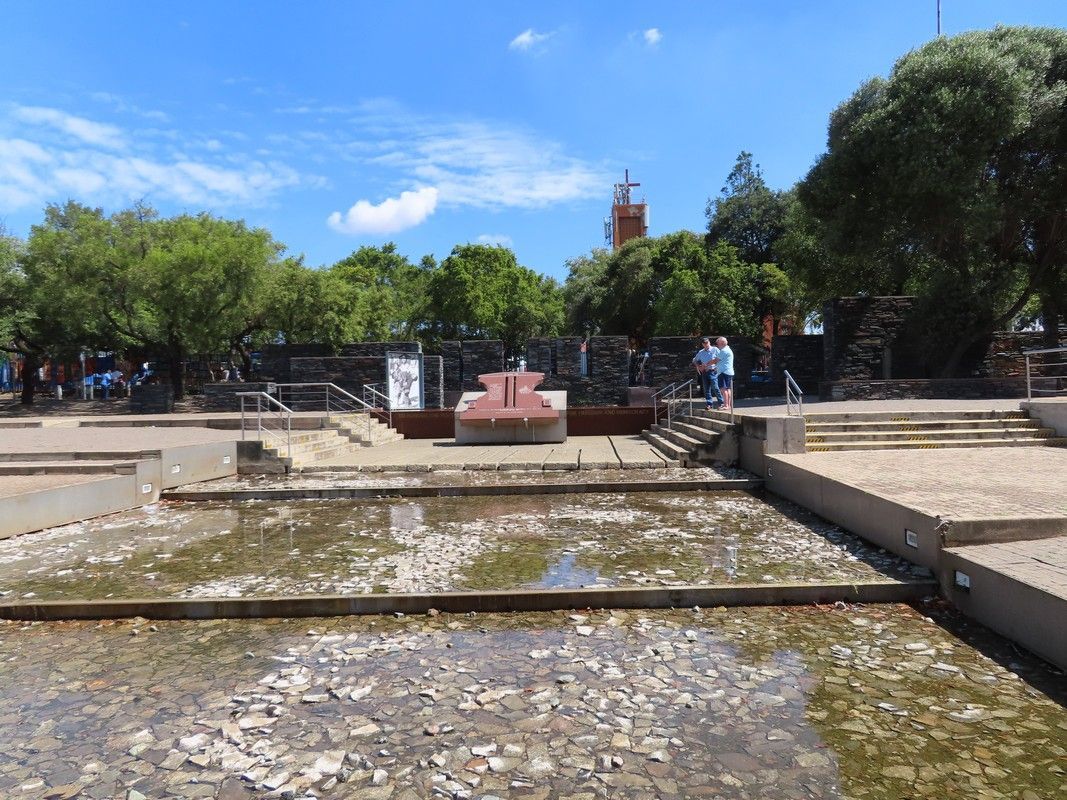 A fountain in a park with trees in the background