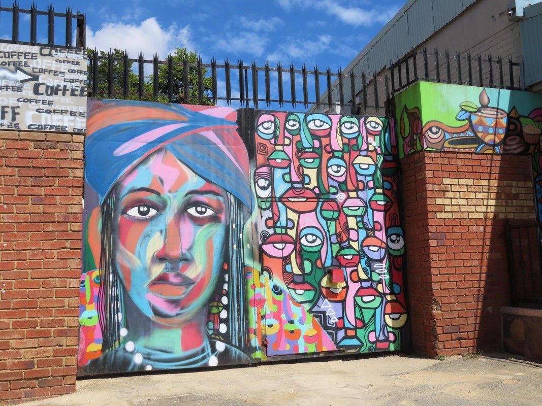A colorful painting of a woman 's face on a brick wall