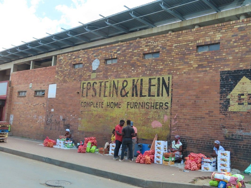 A group of people are standing in front of a building that says epstein & klein on it.