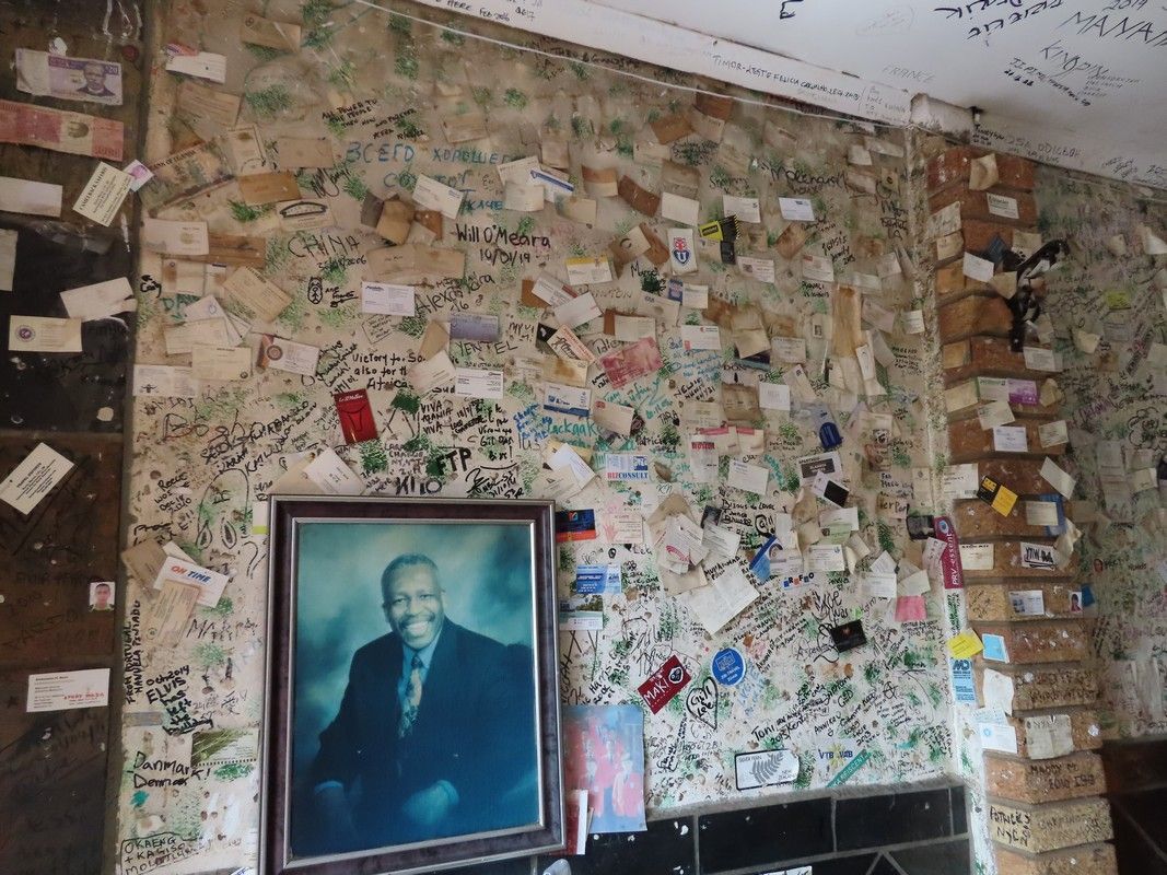 A picture of a man in a suit is hanging on a wall covered in graffiti.