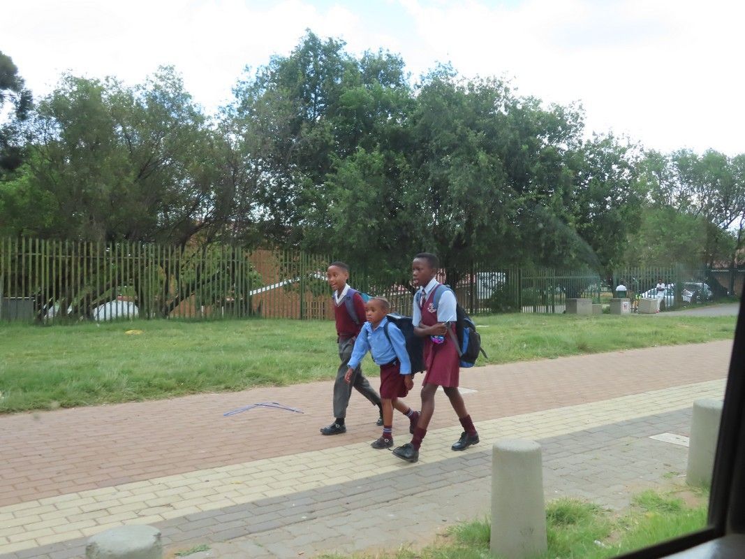 A group of children are walking down a sidewalk.