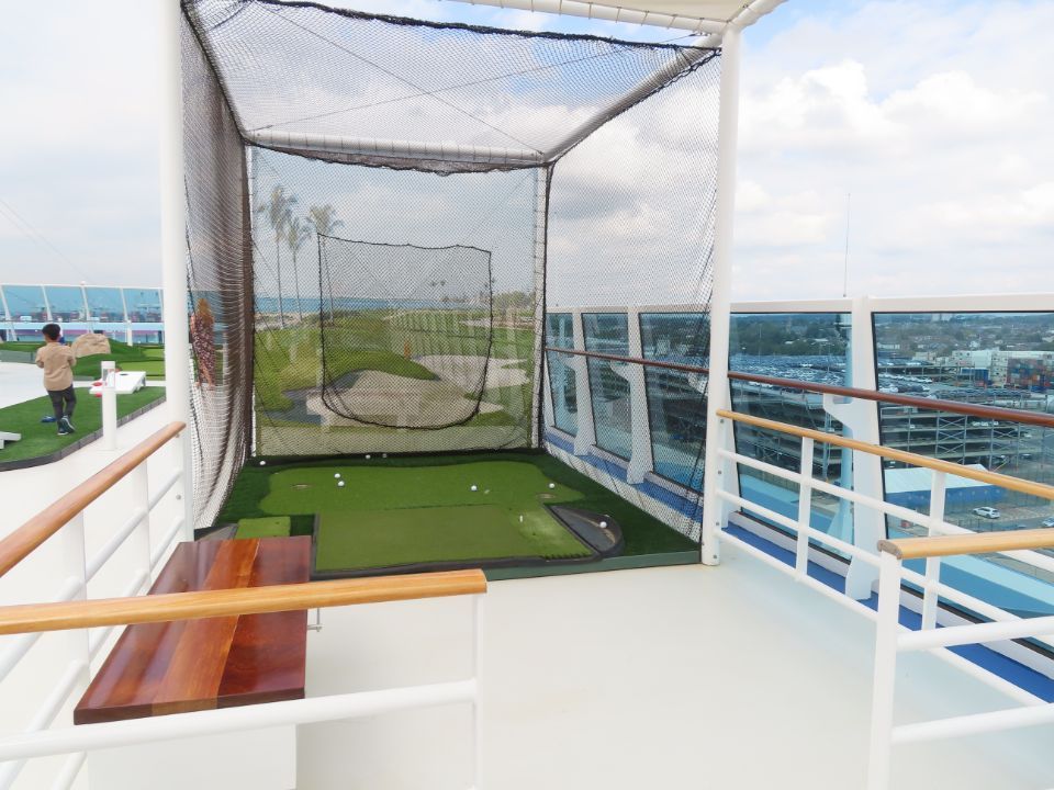 A golf net on a balcony with a view of the ocean