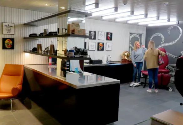 A group of people are standing around a counter in a room.