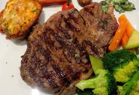 a white plate topped with a steak , broccoli , carrots and potatoes .
