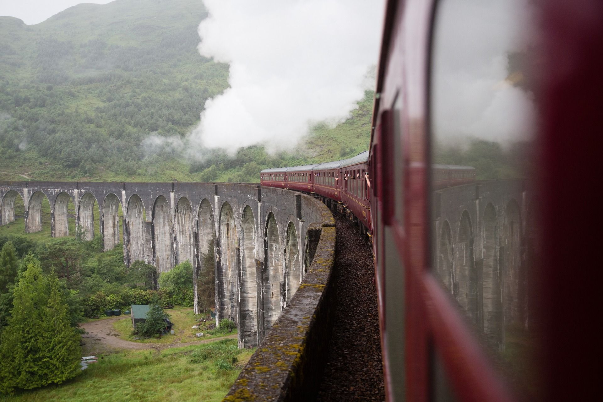 A train is going over a bridge with smoke coming out of it.