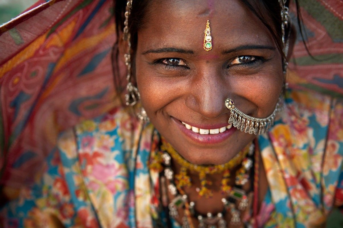 A close up of a woman wearing a nose ring and smiling.