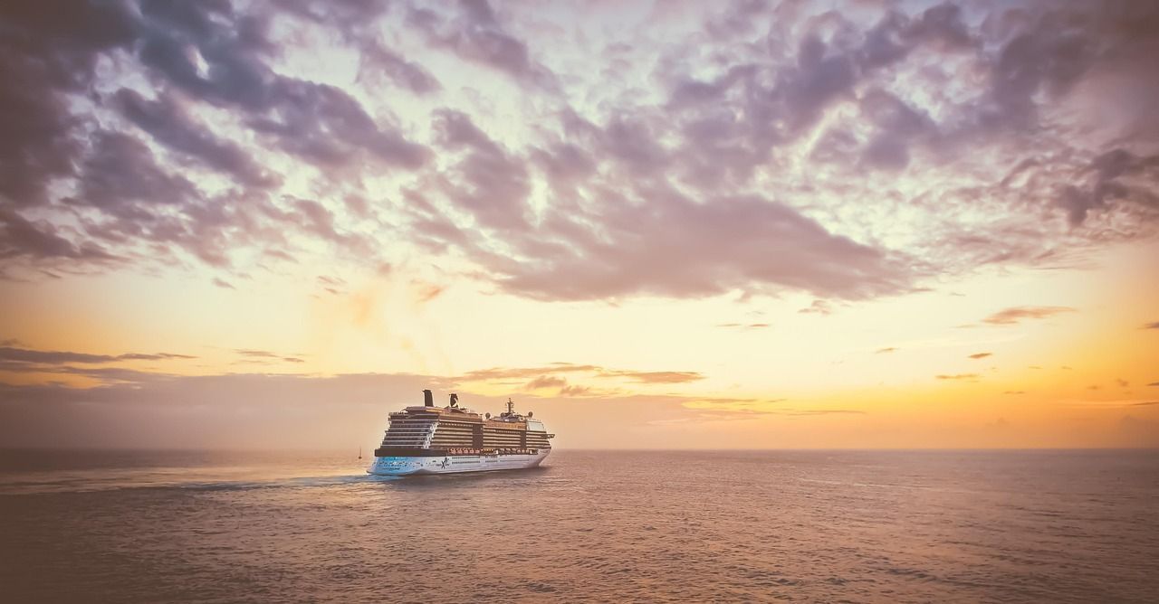 A cruise ship is at sea at sunset on a world cruise.
