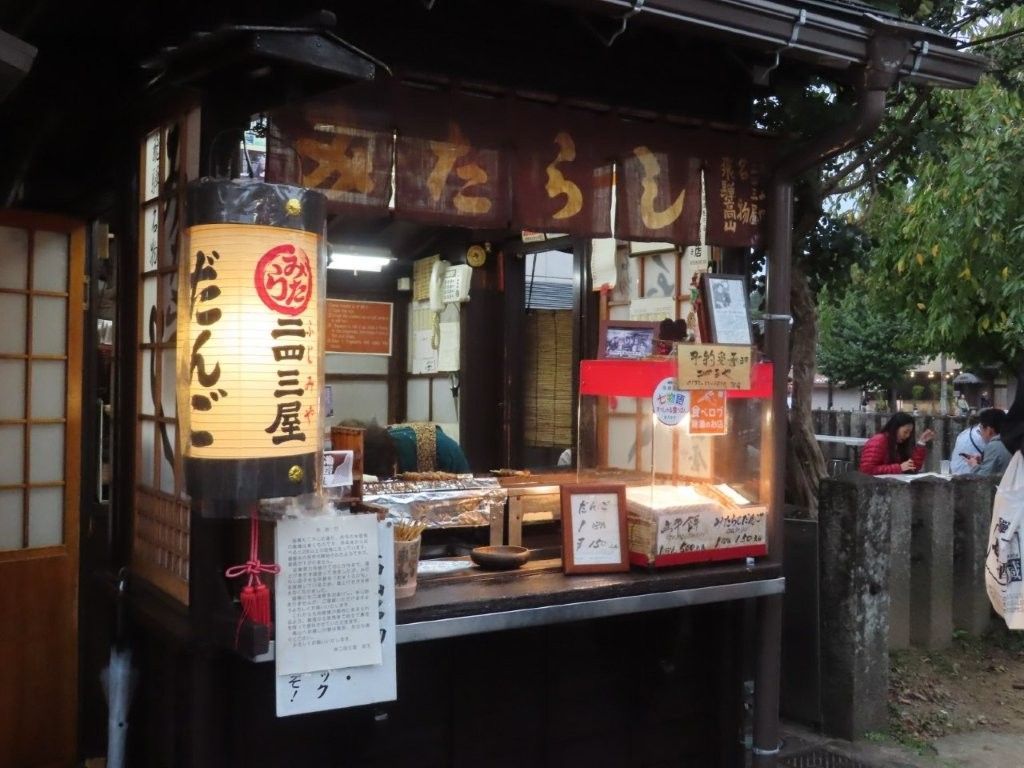 Food stall with Japanese signage, illuminated lantern, and menu displayed.