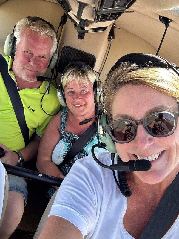 A group of people wearing headphones and sunglasses are sitting in a plane.