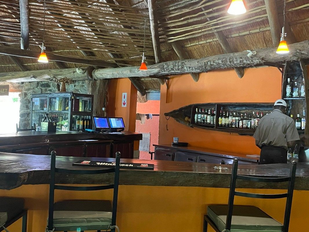 A man is standing behind a bar in a restaurant