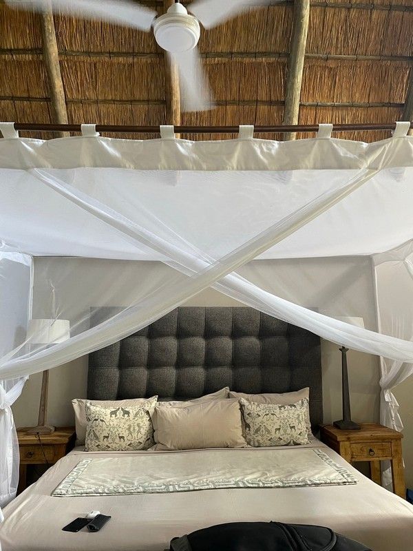 A bedroom with a canopy bed and a ceiling fan.