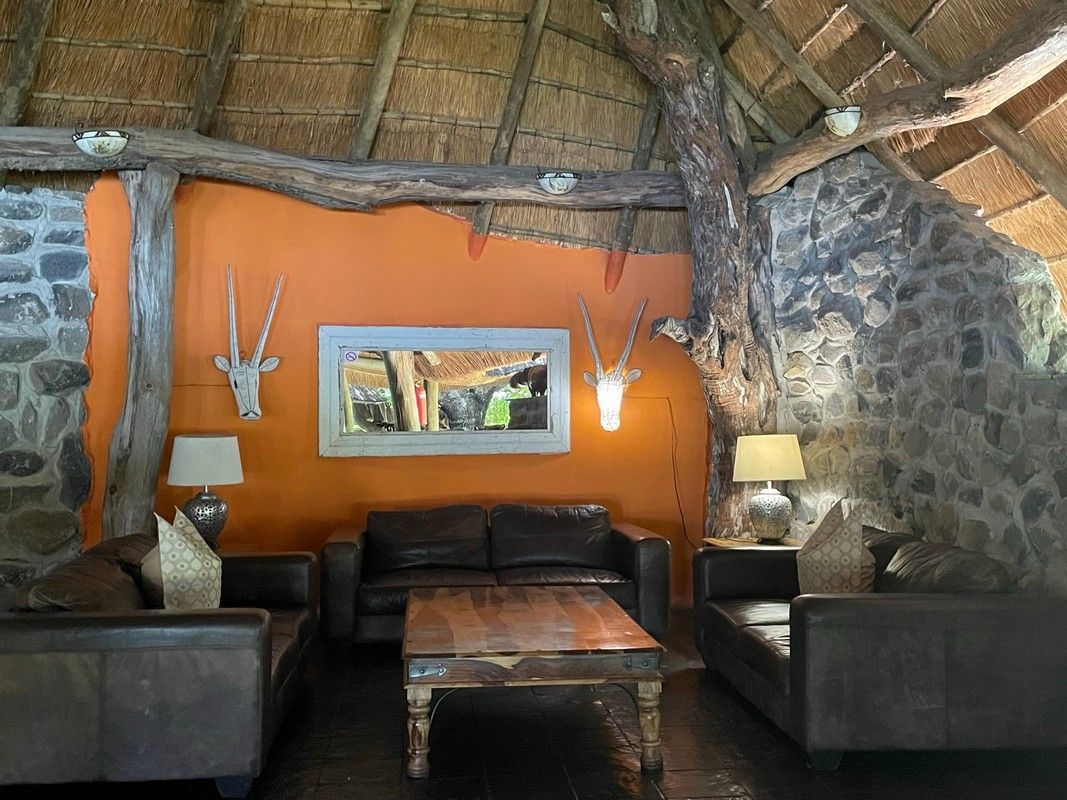 A living room with two couches , a coffee table , and a thatched roof.
