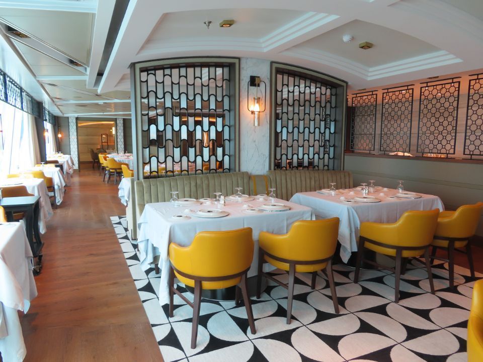 A restaurant with yellow chairs and white tables