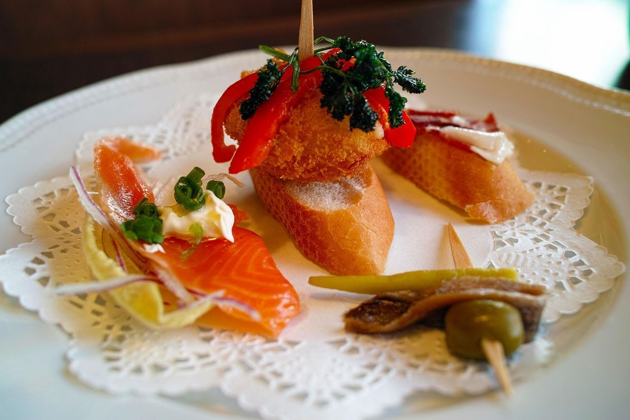 A white plate topped with a variety of food on a napkin pintxos in barcelona on an urban adventures tour