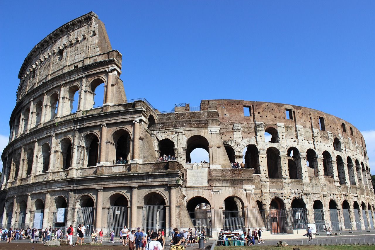 A group of people are standing in front of the colosseum in rome on an urban adventures tour