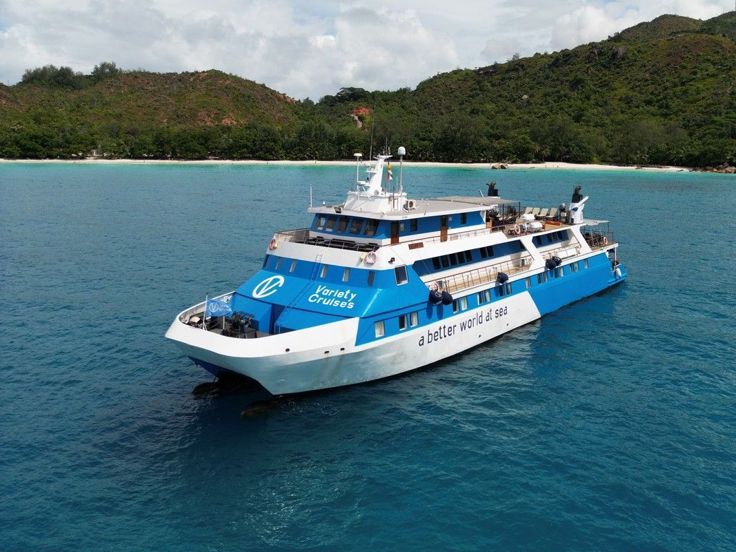 M/Y Pegasos Blue and white cruise ship on the ocean, near a tropical coastline.
