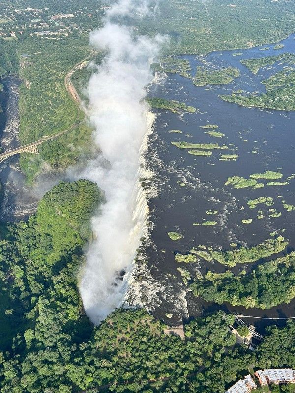An aerial view of a waterfall surrounded by trees
