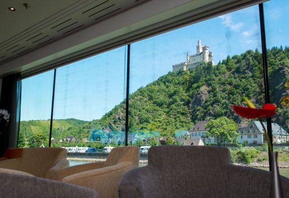a large window with a view of a castle on a hill from onboard Avalon Envision