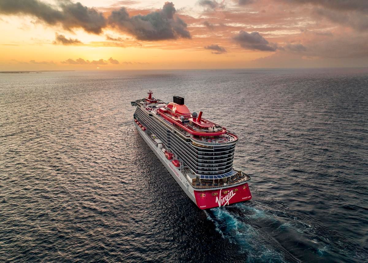 An aerial view of a cruise ship in the ocean at sunset.