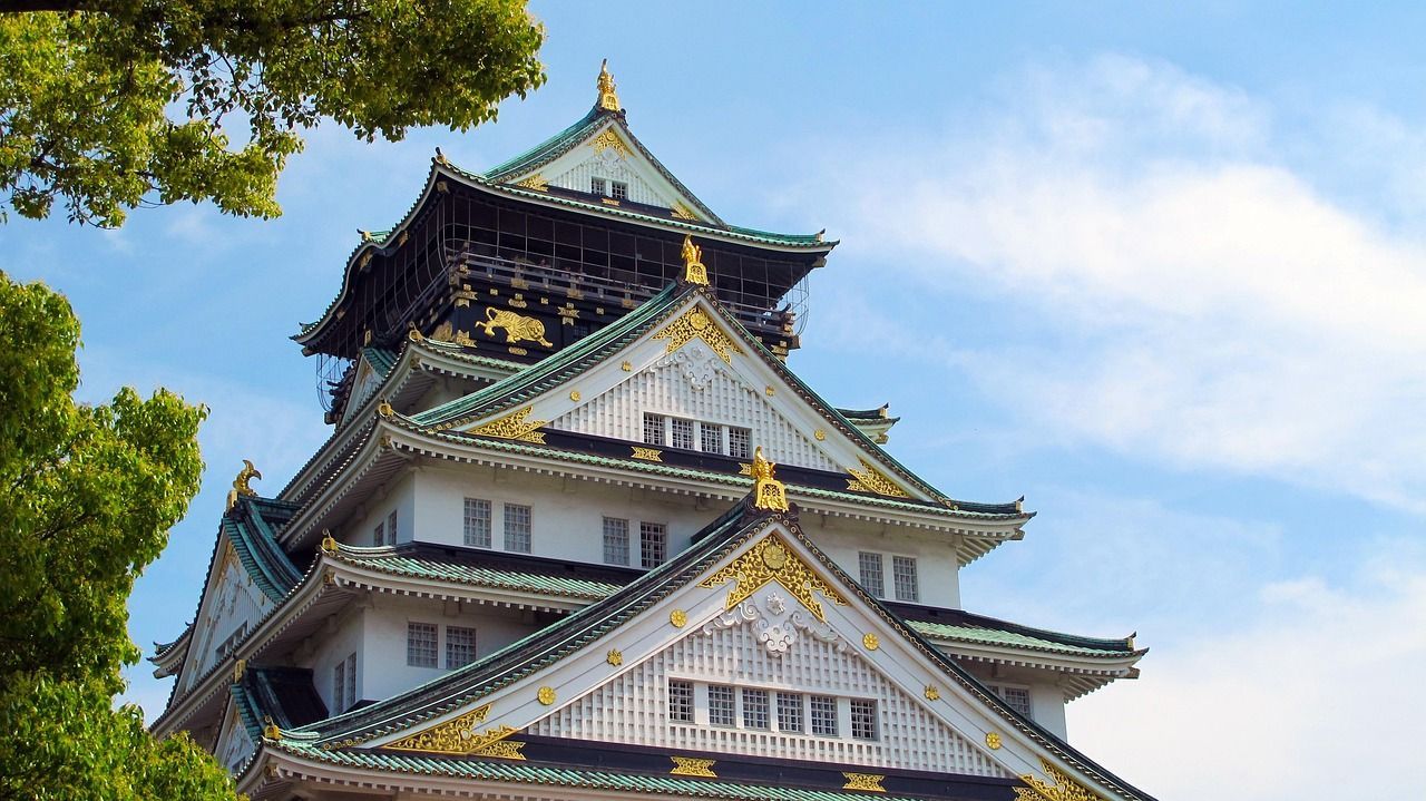A large building with a clock on the top of it in osaka part of Princess Cruises 2027 World Cruise