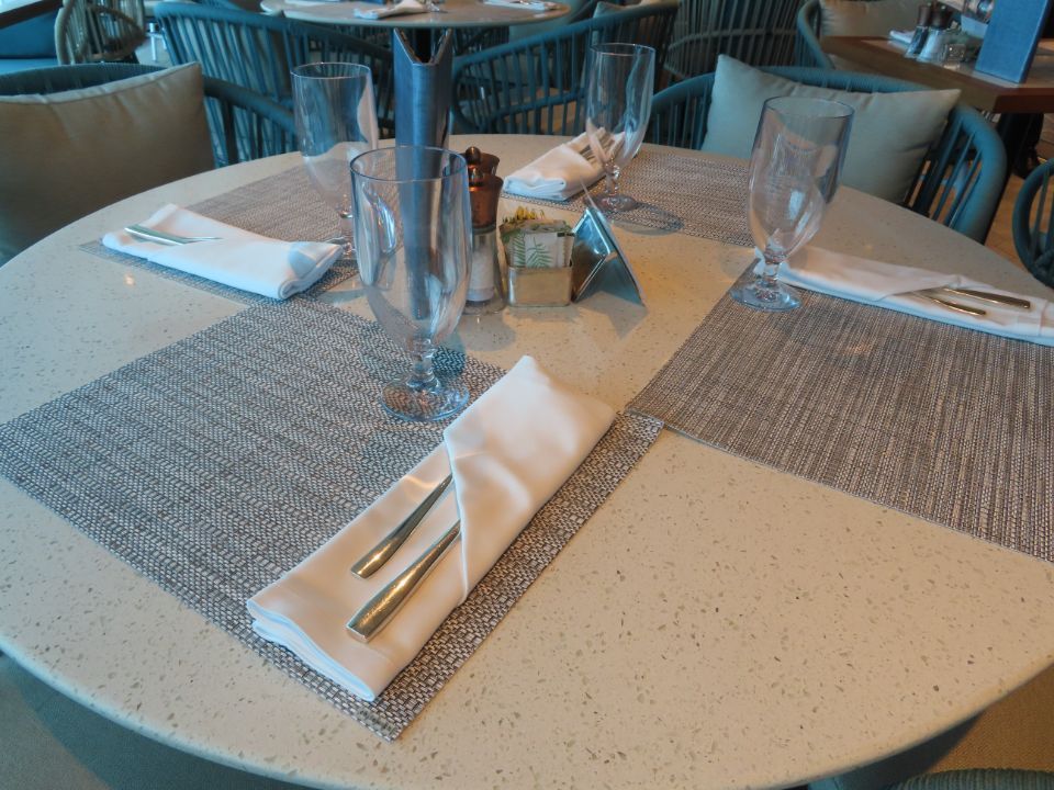 A round table with a napkin and silverware on it