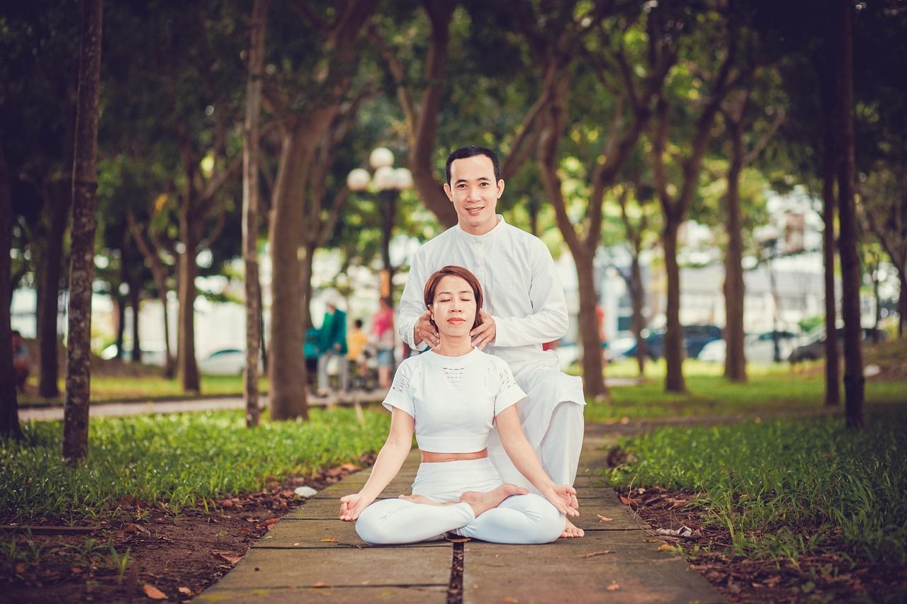Wellness tours with G Adventures A man and a woman are sitting in a lotus position in a park.