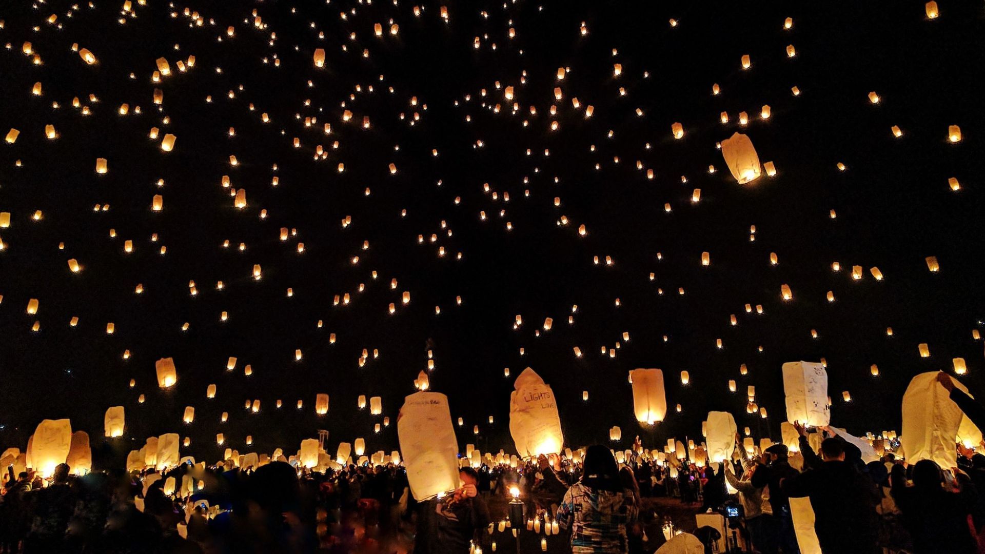 a group of people are watching lanterns being released into the night sky at the January Lantern Festival