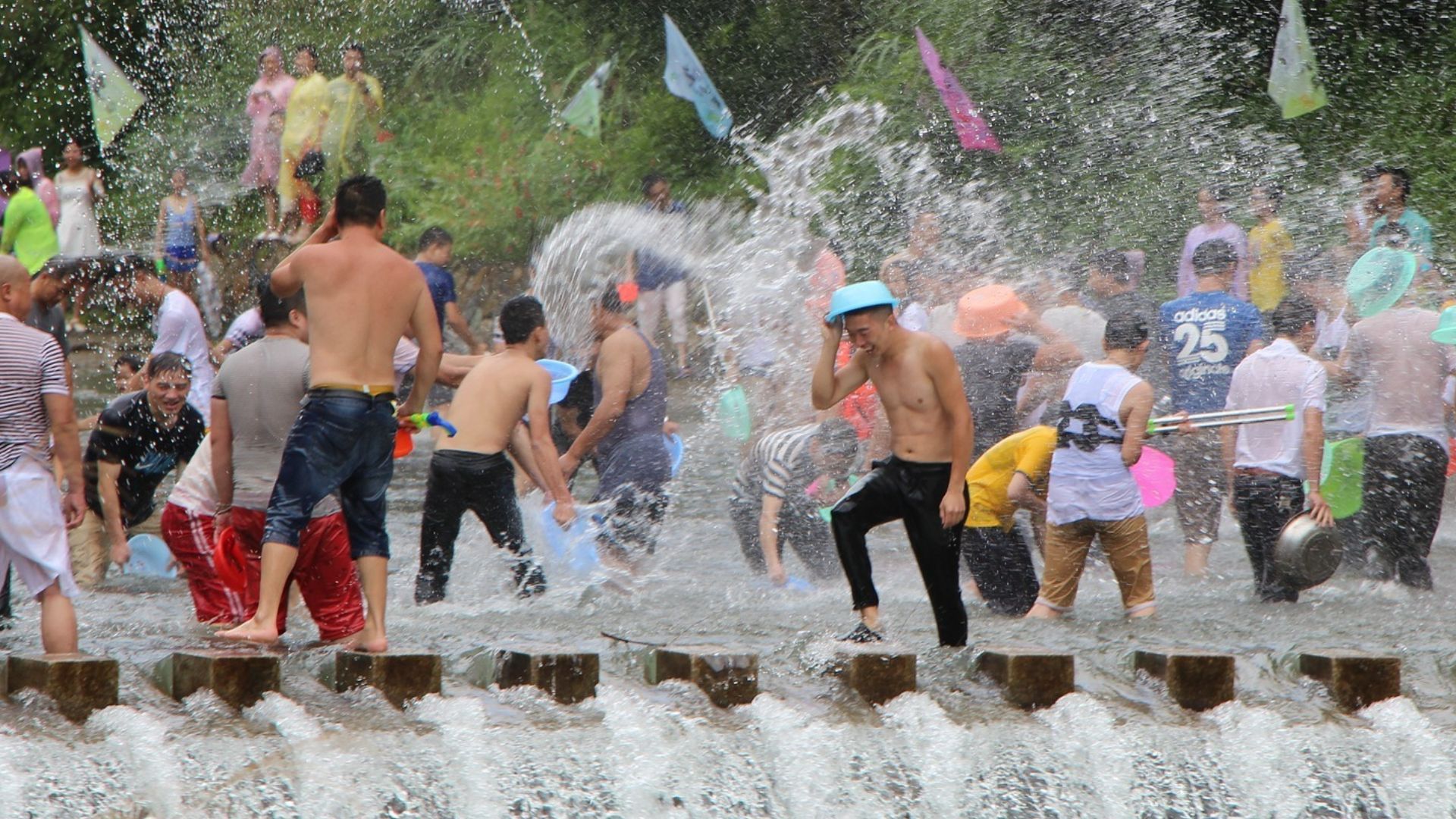 a group of people throwing water at the Songkran festival