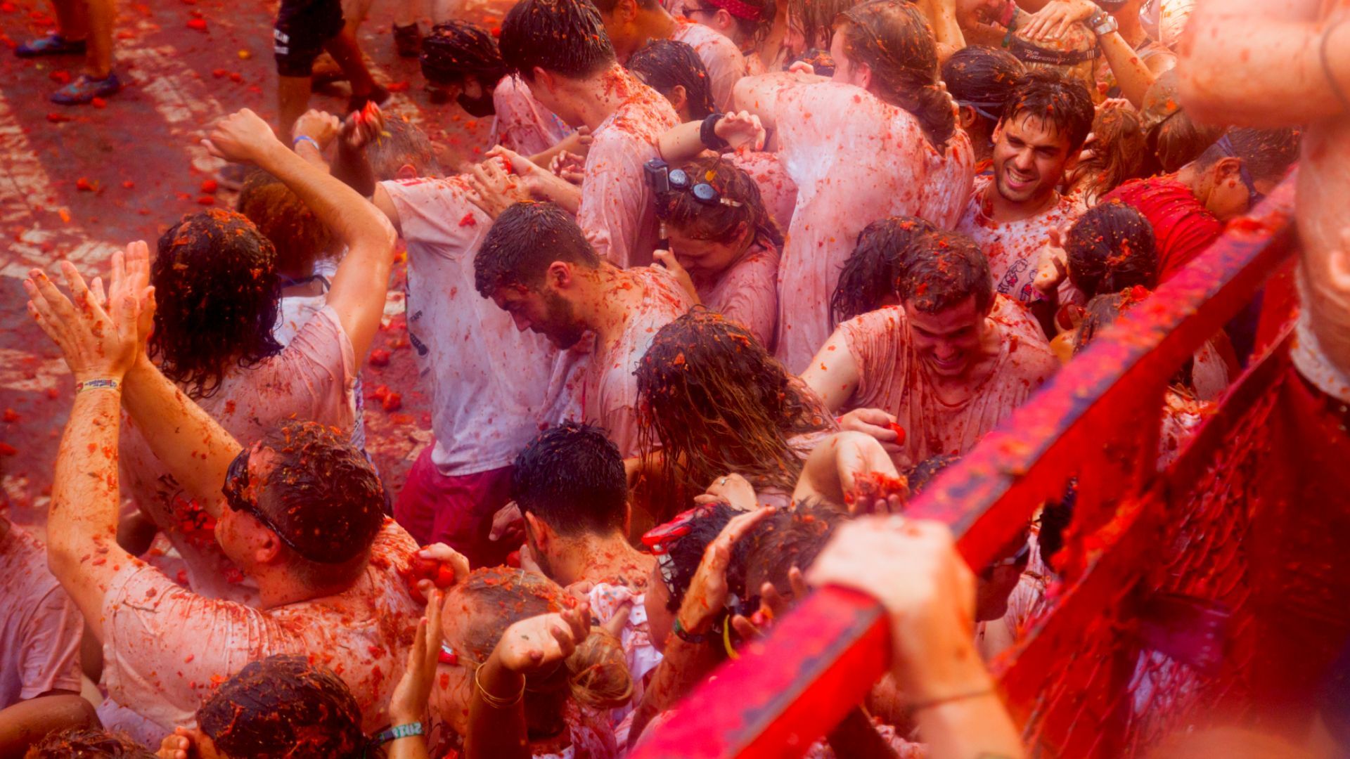 a crowd of people are covered in tomatos at the La Tomatina festival in Spain