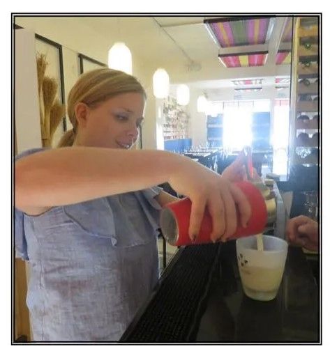 A woman is pouring a drink into a glass