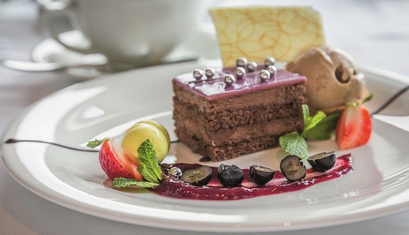 a white plate topped with a piece of chocolate cake and ice cream .