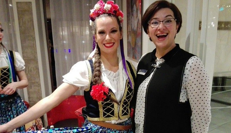 a woman in a polka dot shirt is standing next to a woman in a traditional costume .