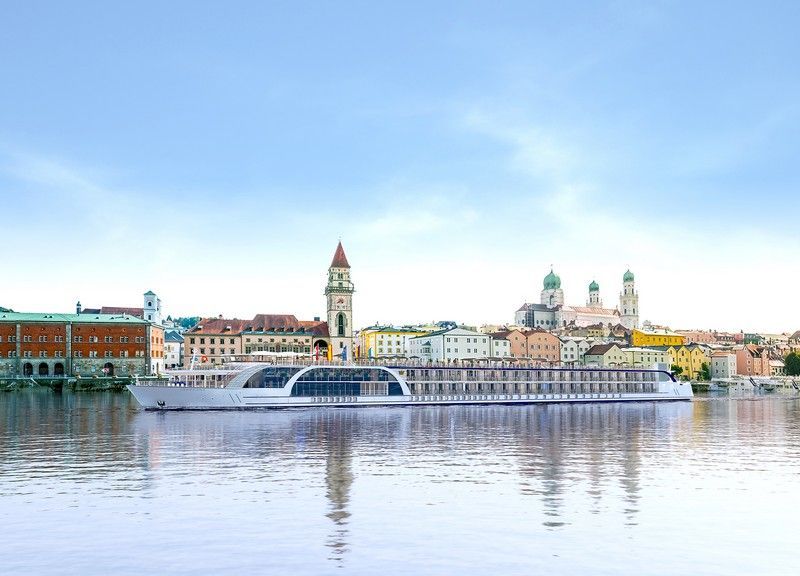 a river cruise ship is floating on top of a river in front of a city 