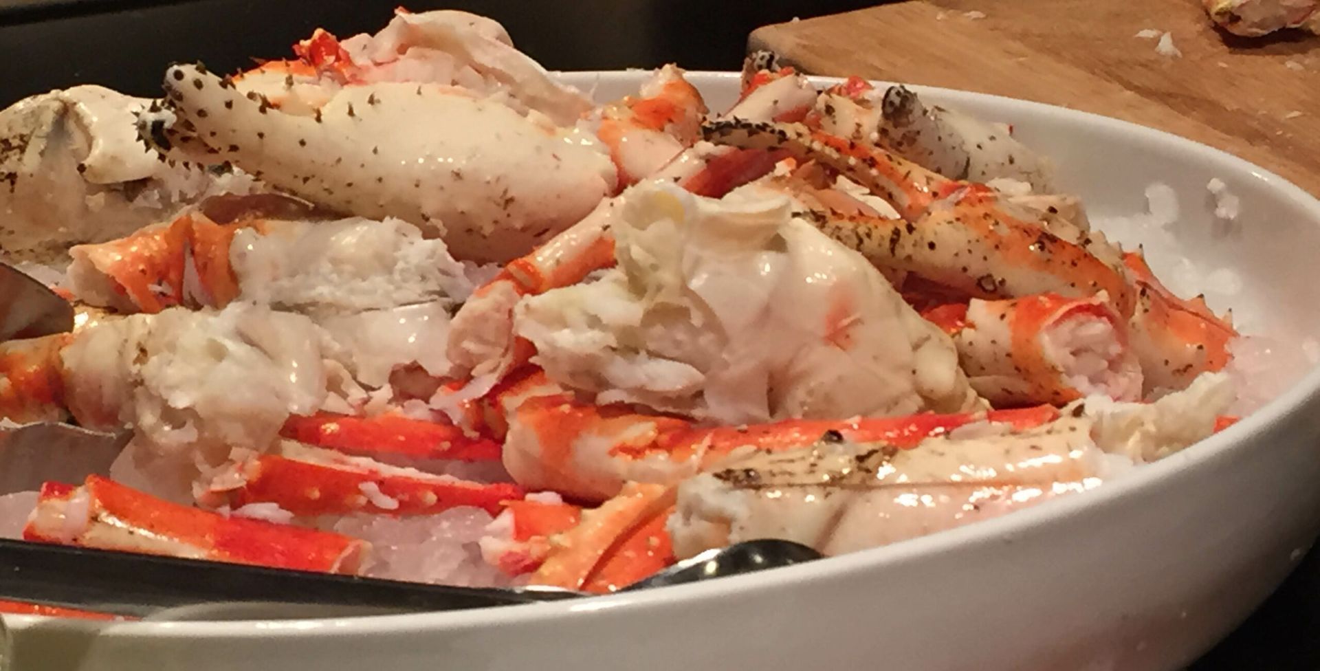 A bowl of crab legs with a spoon in it
