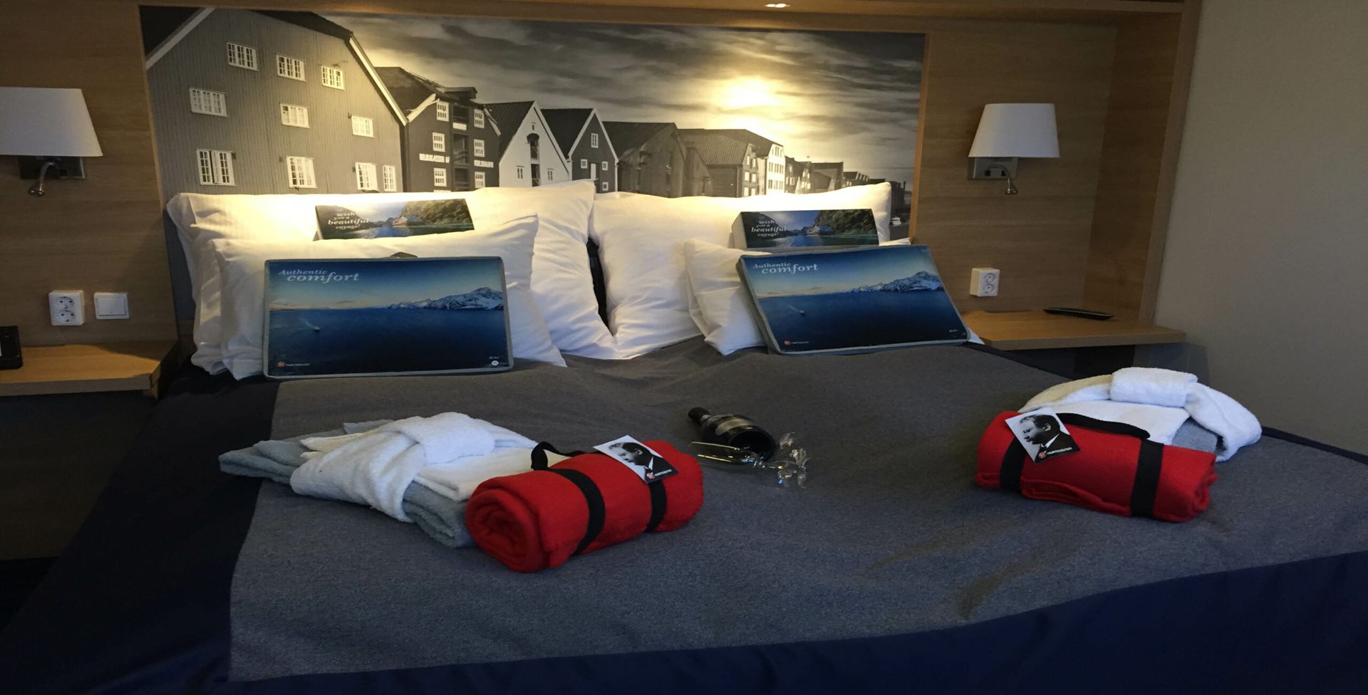 A hotel room with a bed and a painting on the wall.