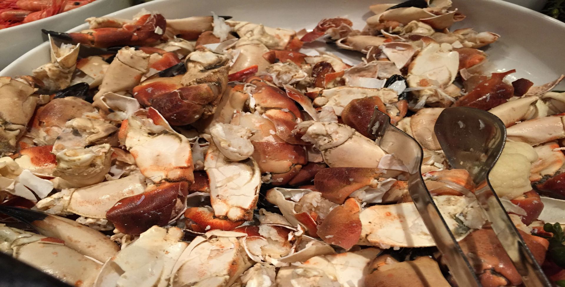 A close up of a plate of food with tongs on it.