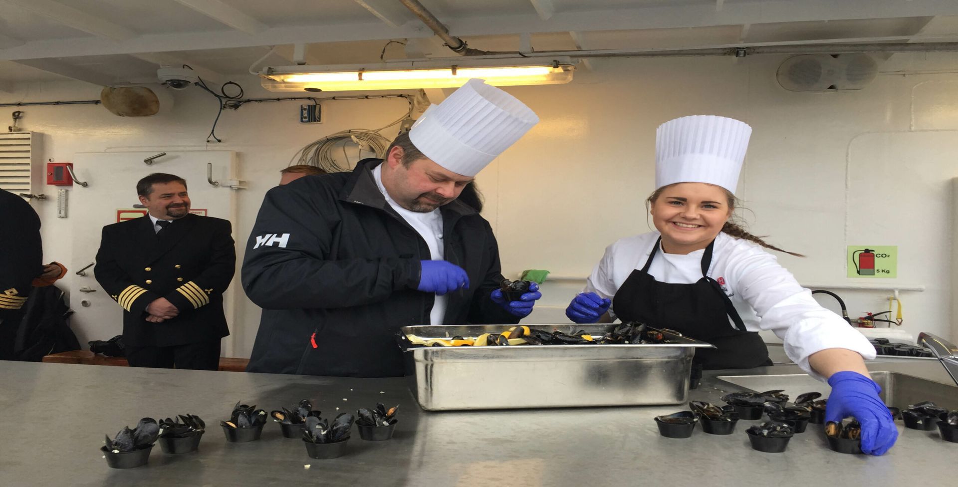 A man and a woman are preparing food in a kitchen.