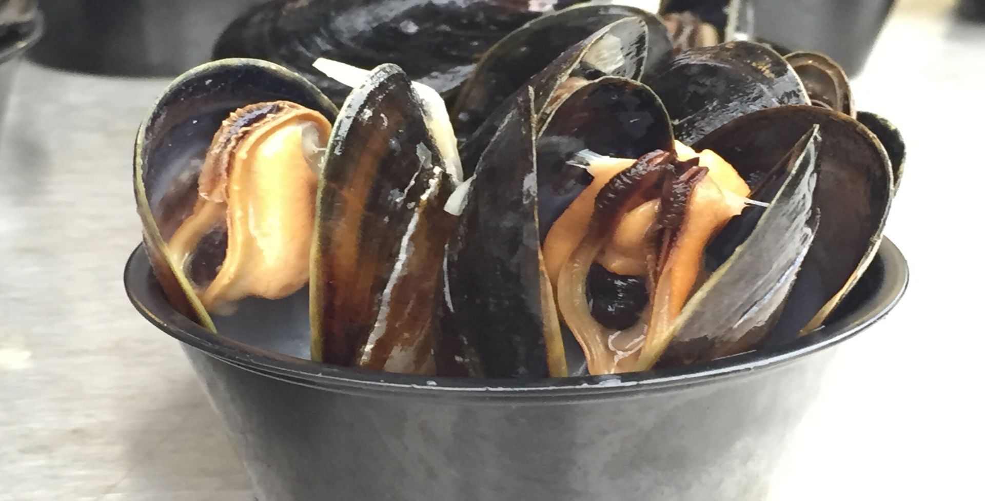 A bowl of mussels is sitting on a table