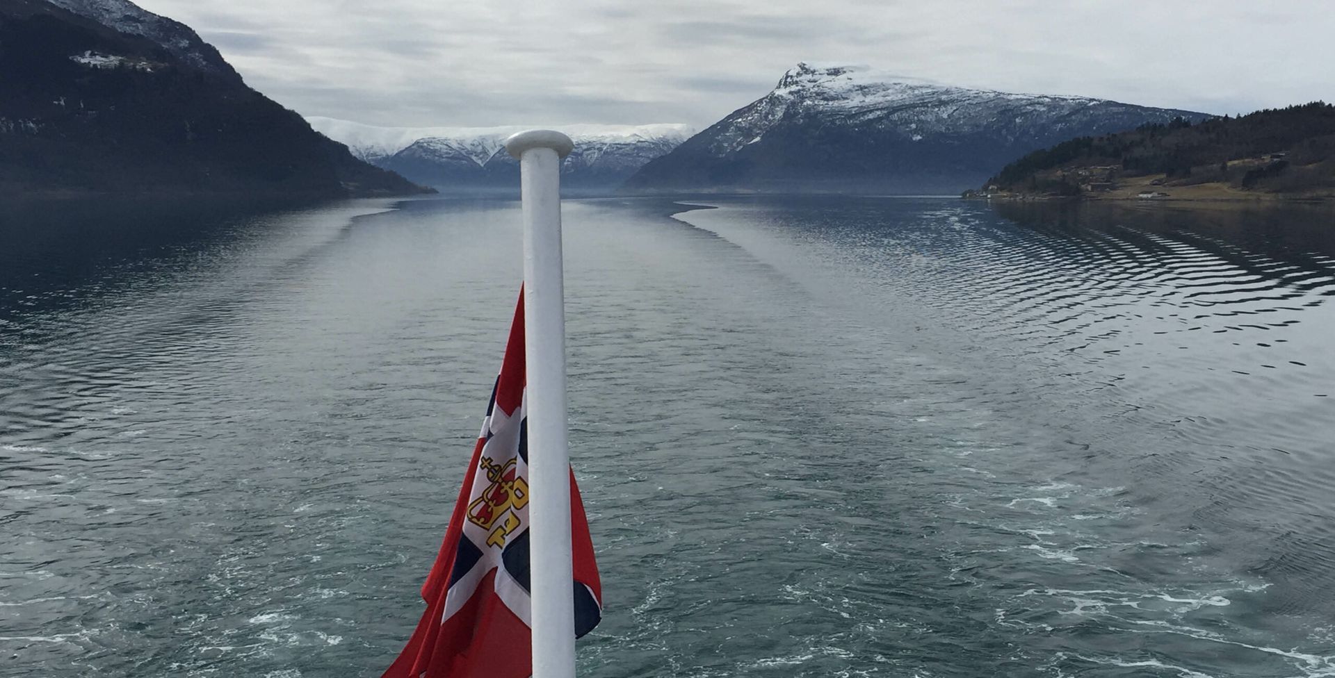 A red and white flag is flying over a body of water