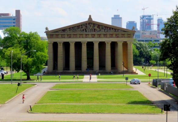 The Parthenon, Nashville,a large building with columns is sitting in the middle of a park .