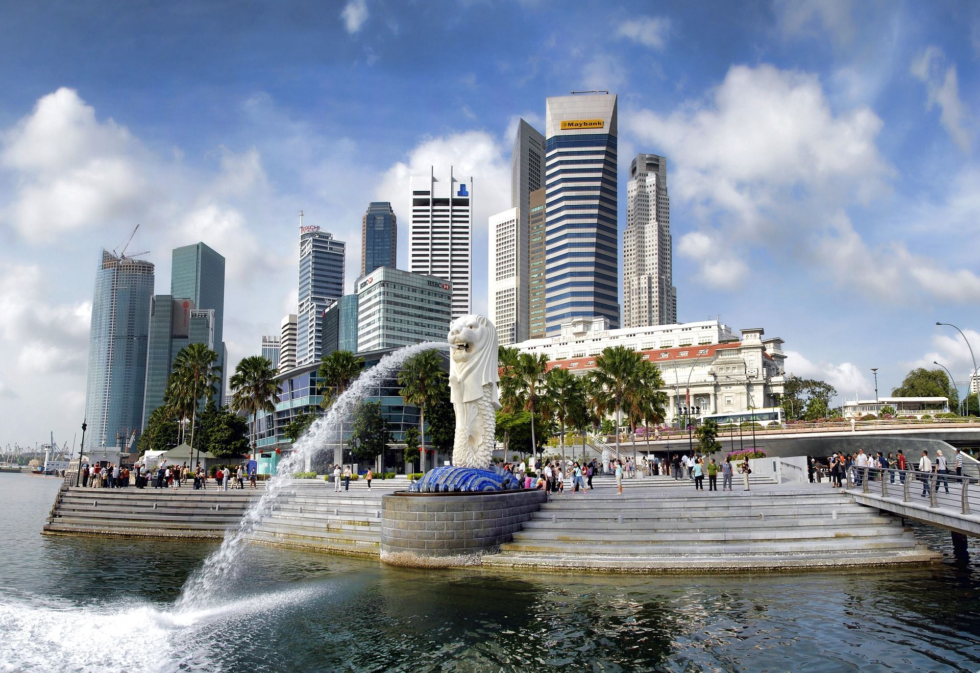 A fountain is spraying water in front of a city skyline in Singapore