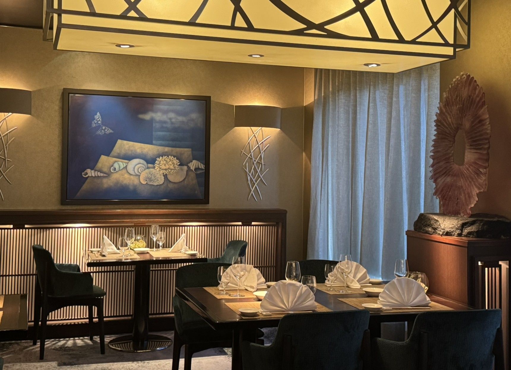 Elegant restaurant dining area with a table set for a meal, art on the walls, and warm lighting.