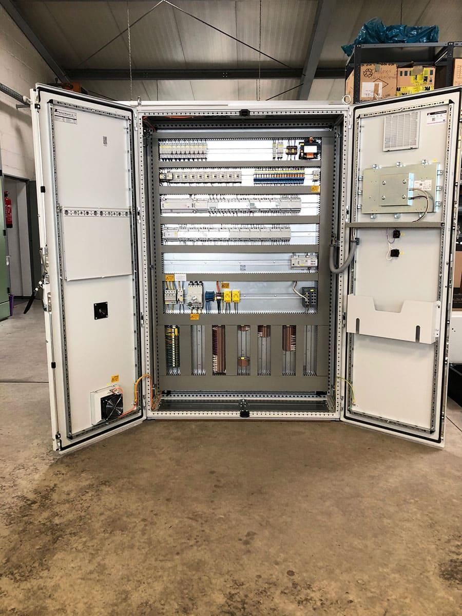 Ein großer Schaltkasten mit geöffneten Türen in einer Lagerhalle.