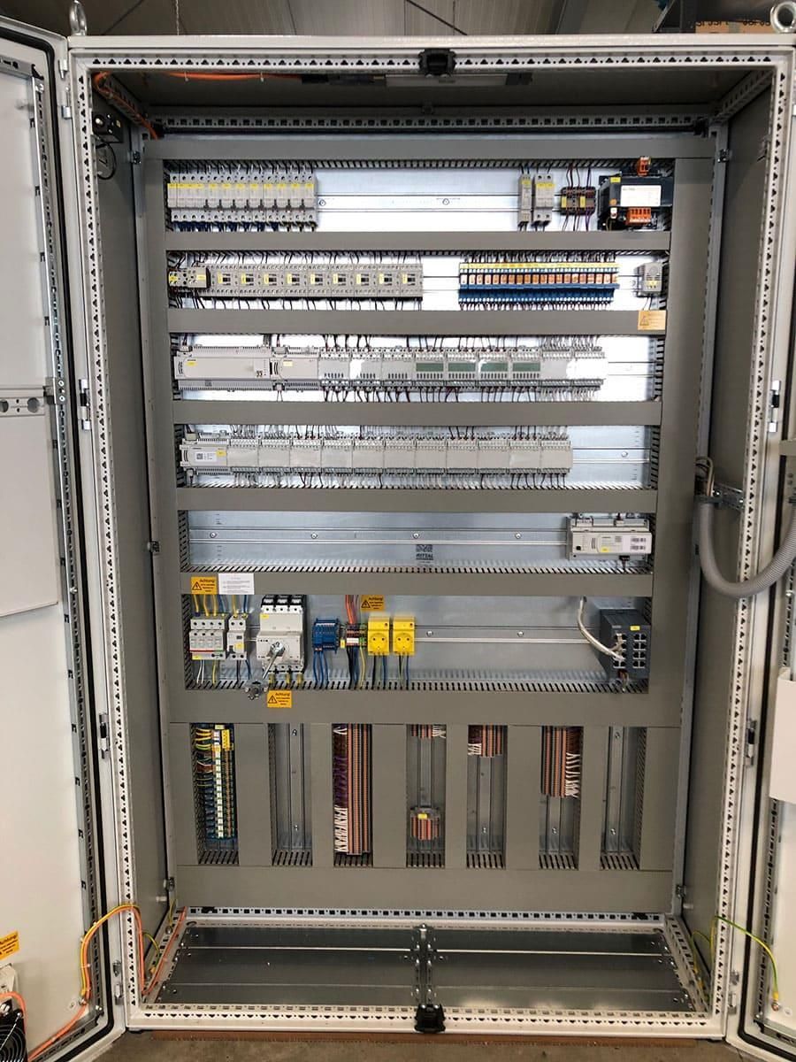 Eine große elektrische Schalttafel, aus der viele Kabel herausführen.