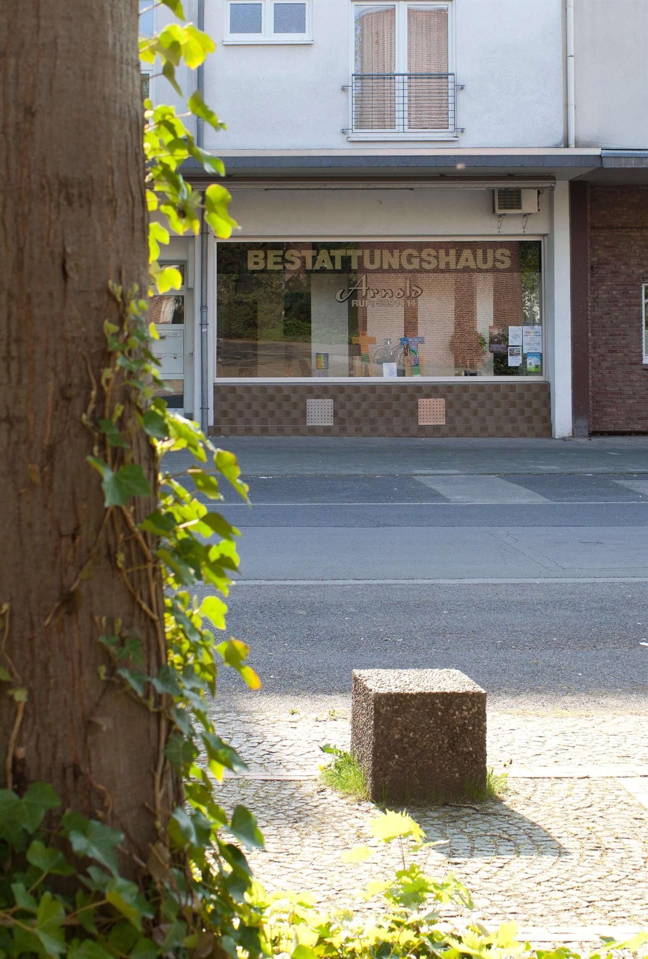Ein Gebäude mit einer Ladenfront, auf der „Bestattungshaus“ steht