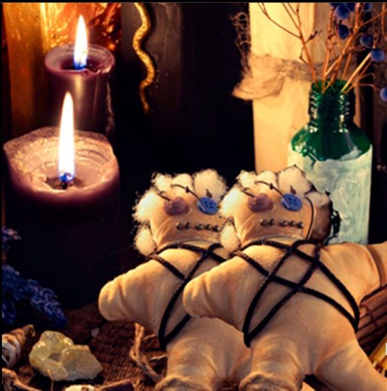 Dos muñecos vudú con velas y frascos en un entorno poco iluminado.